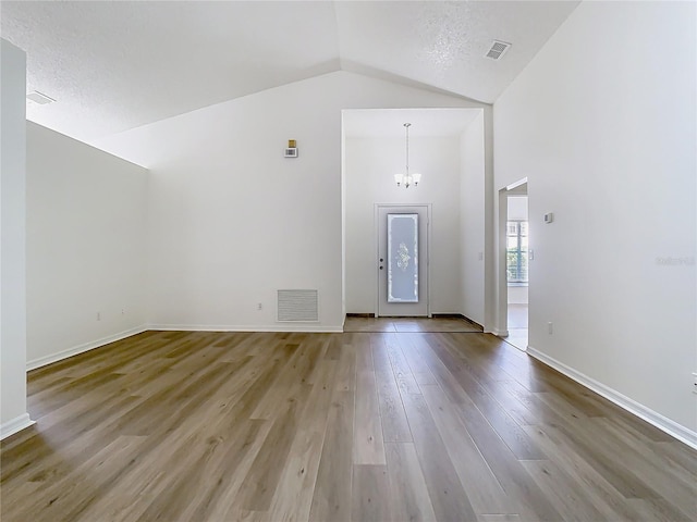1851 Hammock Moss Dr, Orlando, FL 32820 - unfurnished living room with a chandelier, wood finished floors, baseboards, and high vaulted ceiling