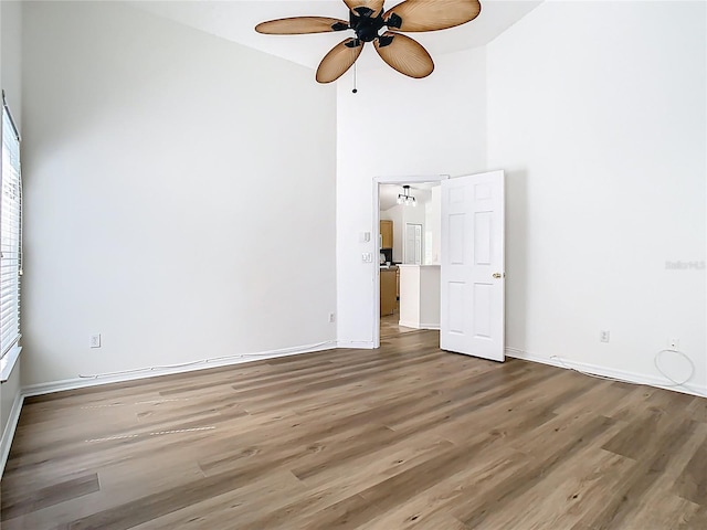 1851 Hammock Moss Dr, Orlando, FL 32820 - unfurnished bedroom featuring wood finished floors, baseboards, a towering ceiling, and multiple windows