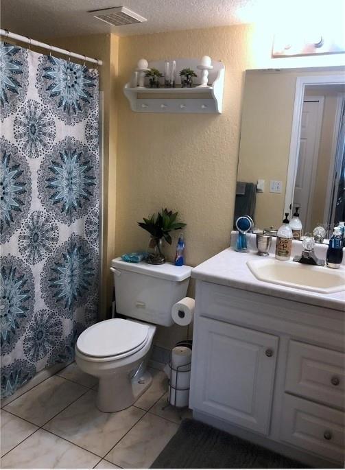 13838 Fairway Island Dr Unit 1418, Orlando, FL 32837 - bathroom with toilet, vanity, curtained shower, and tile patterned flooring
