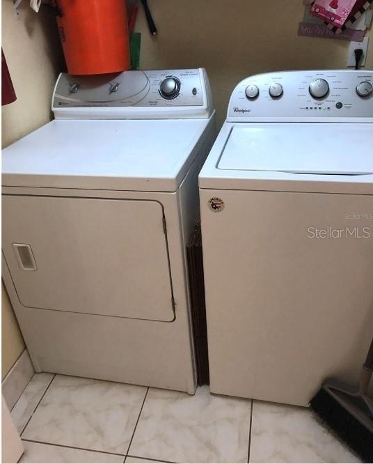 13838 Fairway Island Dr Unit 1418, Orlando, FL 32837 - laundry room featuring washer and clothes dryer and light tile patterned floors