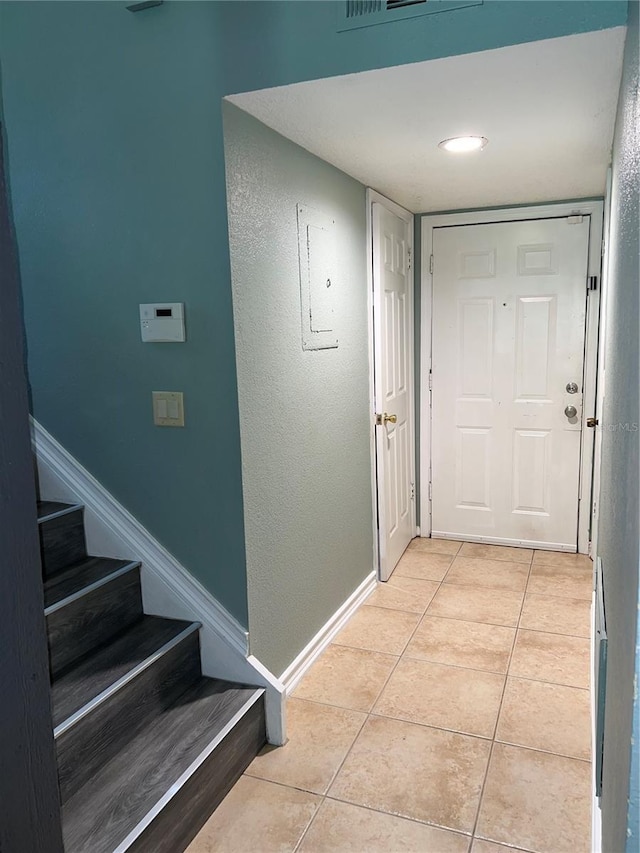5826 Peregrine Ave Unit F01, Orlando, FL 32819 - hallway with light tile patterned floors, stairs, and baseboards