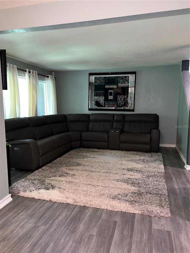 5826 Peregrine Ave Unit F01, Orlando, FL 32819 - living room featuring dark wood-style flooring, a textured ceiling, and baseboards