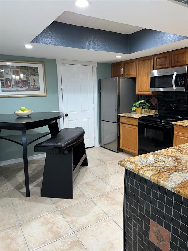 5826 Peregrine Ave Unit F01, Orlando, FL 32819 - kitchen with appliances with stainless steel finishes, decorative backsplash, light tile patterned floors, light stone counters, and recessed lighting