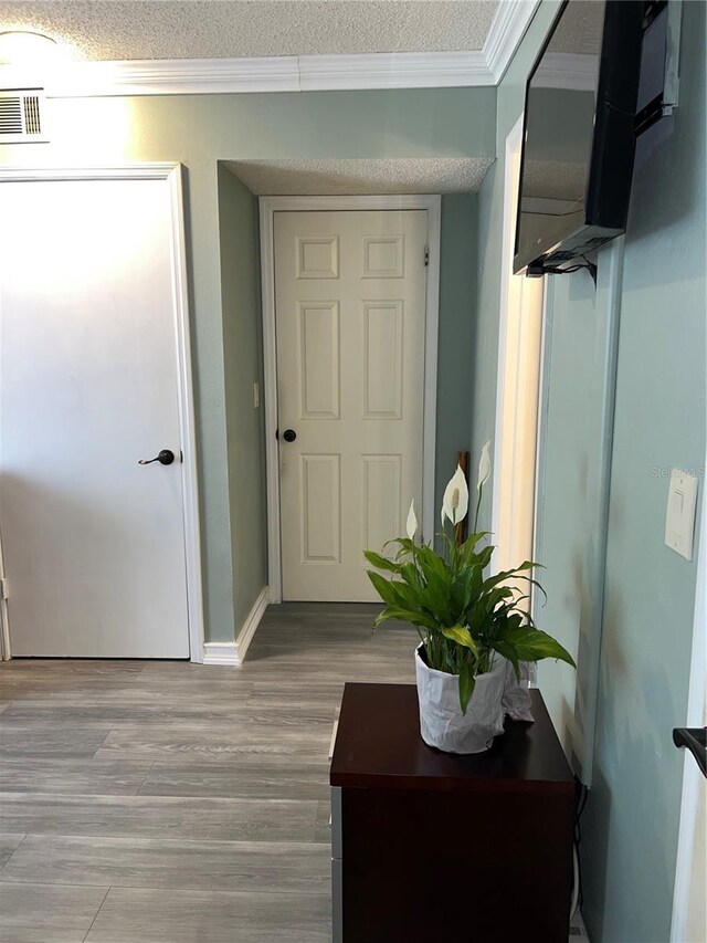 5826 Peregrine Ave Unit F01, Orlando, FL 32819 - hall with crown molding, wood finished floors, a textured ceiling, and baseboards