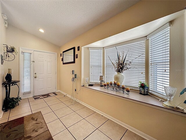 1364 Rebecca Dr, Haines City, FL 33844 - entrance foyer with light tile patterned floors, a textured ceiling, lofted ceiling, baseboards, and recessed lighting