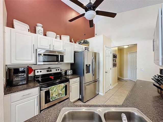 1364 Rebecca Dr, Haines City, FL 33844 - kitchen featuring appliances with stainless steel finishes, dark countertops, white cabinets, a ceiling fan, and high vaulted ceiling