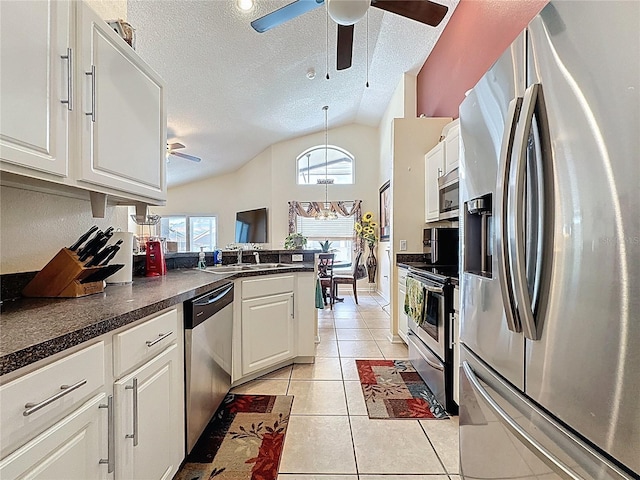 1364 Rebecca Dr, Haines City, FL 33844 - kitchen featuring appliances with stainless steel finishes, a ceiling fan, lofted ceiling, light tile patterned floors, and white cabinetry