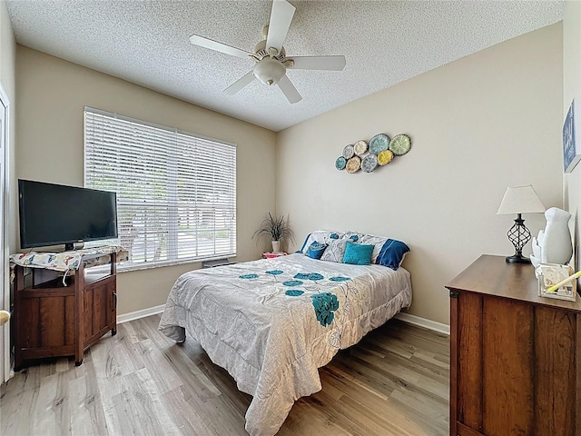1364 Rebecca Dr, Haines City, FL 33844 - bedroom with light wood-style flooring, baseboards, a textured ceiling, and ceiling fan