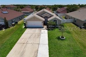 3030 Eagle Crossing Dr, Kissimmee, FL 34746 - view of front of home featuring driveway, a garage, a front yard, and a residential view
