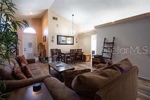 3030 Eagle Crossing Dr, Kissimmee, FL 34746 - living room featuring dark wood finished floors and lofted ceiling