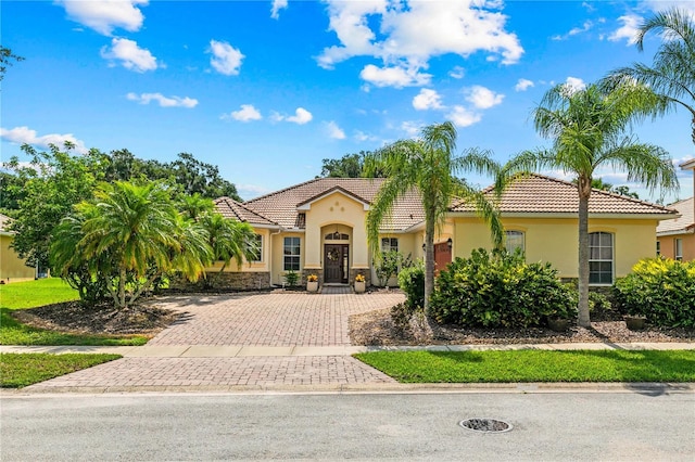 3427 Harborside Ct, Kissimmee, FL 34746 - mediterranean / spanish-style house with a tile roof, stucco siding, and decorative driveway