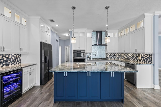 3427 Harborside Ct, Kissimmee, FL 34746 - kitchen with wine cooler, wall chimney exhaust hood, black appliances, dark wood-style flooring, and an island with sink