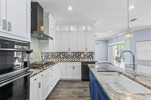 3427 Harborside Ct, Kissimmee, FL 34746 - kitchen featuring appliances with stainless steel finishes, wall chimney range hood, blue cabinetry, white cabinetry, and pendant lighting