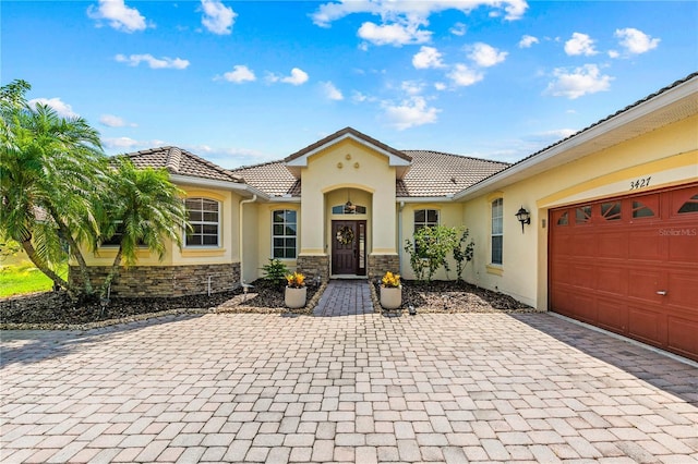 3427 Harborside Ct, Kissimmee, FL 34746 - view of front of home with a tile roof, stucco siding, and decorative driveway