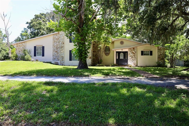 1843 Harbor Blvd, Kissimmee, FL 34744 - view of front facade featuring stone siding and a front lawn