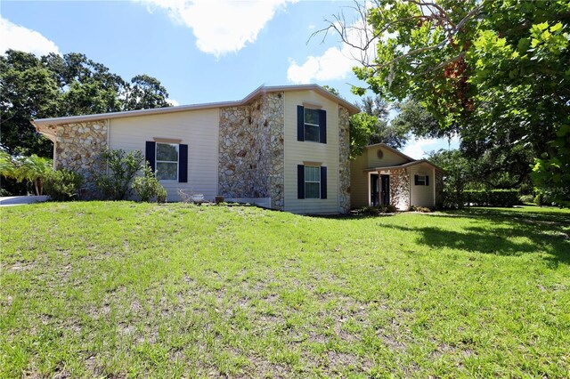 1843 Harbor Blvd, Kissimmee, FL 34744 - view of front facade with stone siding and a front lawn