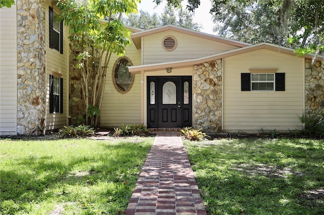 1843 Harbor Blvd, Kissimmee, FL 34744 - doorway to property featuring stone siding and a lawn