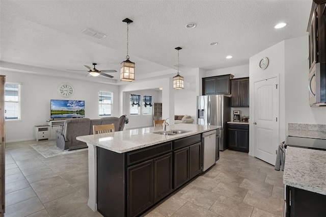 1951 Partin Terrace Rd, Kissimmee, FL 34744 - kitchen featuring open floor plan, appliances with stainless steel finishes, a sink, a ceiling fan, and a textured ceiling