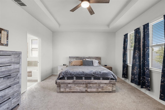 1951 Partin Terrace Rd, Kissimmee, FL 34744 - carpeted bedroom with a tray ceiling, multiple windows, ensuite bathroom, and a ceiling fan