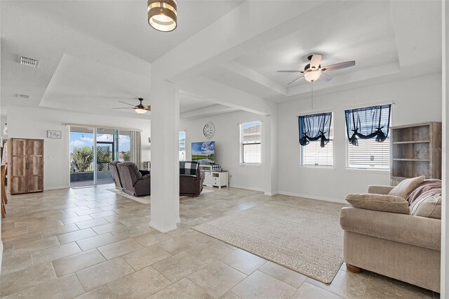 1951 Partin Terrace Rd, Kissimmee, FL 34744 - living area with a ceiling fan, a tray ceiling, healthy amount of natural light, and baseboards