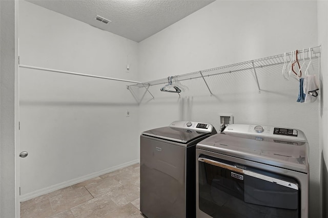 1951 Partin Terrace Rd, Kissimmee, FL 34744 - laundry room featuring washing machine and dryer, baseboards, and a textured ceiling