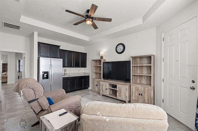 1951 Partin Terrace Rd, Kissimmee, FL 34744 - living area featuring a raised ceiling, a ceiling fan, and a textured ceiling