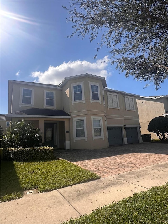 7616 Brookhurst Ln, Kissimmee, FL 34747 - view of front of house featuring an attached garage, stucco siding, and decorative driveway