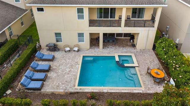 7616 Brookhurst Ln, Kissimmee, FL 34747 - back of house with stucco siding, a shingled roof, a pool with connected hot tub, and a fenced backyard