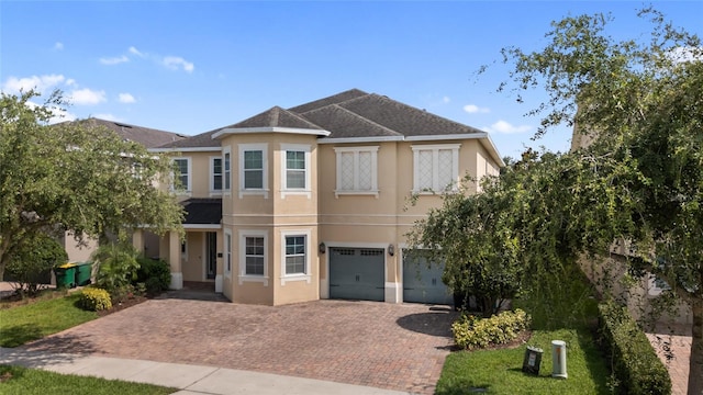 7616 Brookhurst Ln, Kissimmee, FL 34747 - view of front of house with stucco siding, a garage, decorative driveway, and a shingled roof