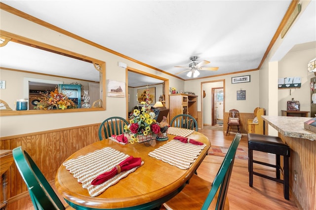 517 Carolina Ave, Saint Cloud, FL 34769 - dining area with light wood-style flooring, ceiling fan, crown molding, and a wainscoted wall