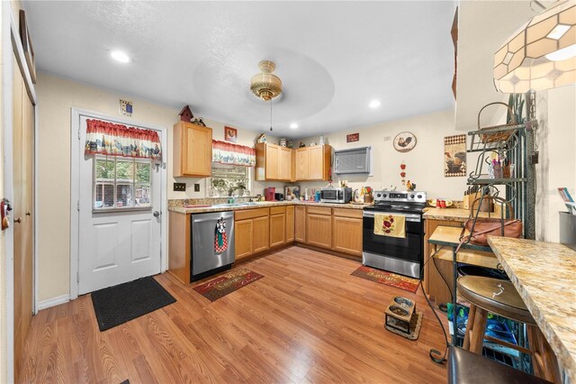 517 Carolina Ave, Saint Cloud, FL 34769 - kitchen with stainless steel appliances, light countertops, light wood-style flooring, light brown cabinetry, and recessed lighting