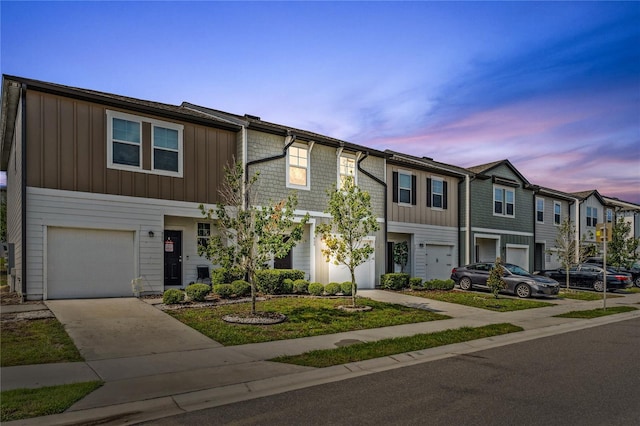 955 Grandin St, Davenport, FL 33837 - townhome / multi-family property featuring board and batten siding, an attached garage, concrete driveway, and a residential view