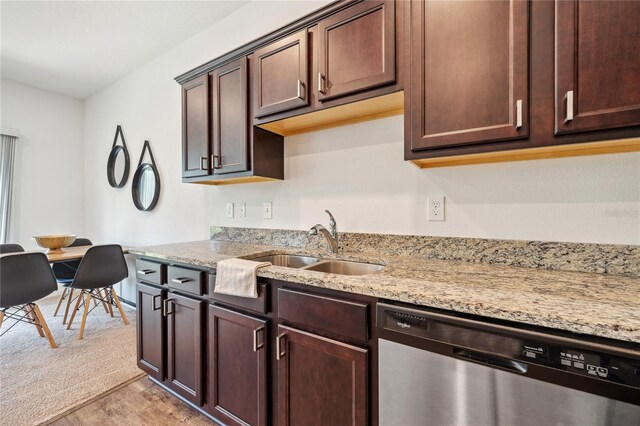 955 Grandin St, Davenport, FL 33837 - kitchen featuring stainless steel dishwasher, a sink, light wood-type flooring, light stone counters, and dark brown cabinetry