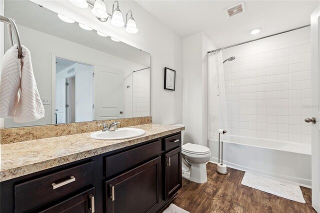 955 Grandin St, Davenport, FL 33837 - bathroom with wood finished floors, vanity, toilet, and shower / bath combo with shower curtain