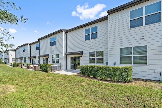 955 Grandin St, Davenport, FL 33837 - back of house featuring central AC, a lawn, a patio, and a residential view