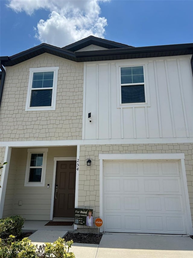 254 Mandovi St, Davenport, FL 33837 - view of property with board and batten siding, an attached garage, and driveway