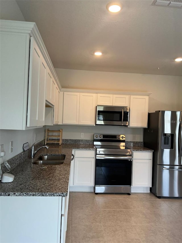 254 Mandovi St, Davenport, FL 33837 - kitchen featuring stainless steel appliances, white cabinets, a sink, dark stone counters, and recessed lighting