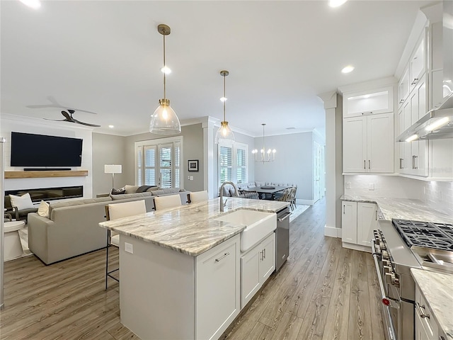 960 Civitas Way, Winter Garden, FL 34787 - kitchen featuring ornamental molding, a sink, light wood finished floors, ceiling fan, and wall chimney exhaust hood