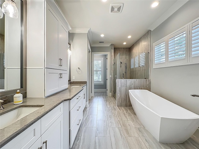 960 Civitas Way, Winter Garden, FL 34787 - bathroom with a shower stall, double vanity, a freestanding bath, and recessed lighting