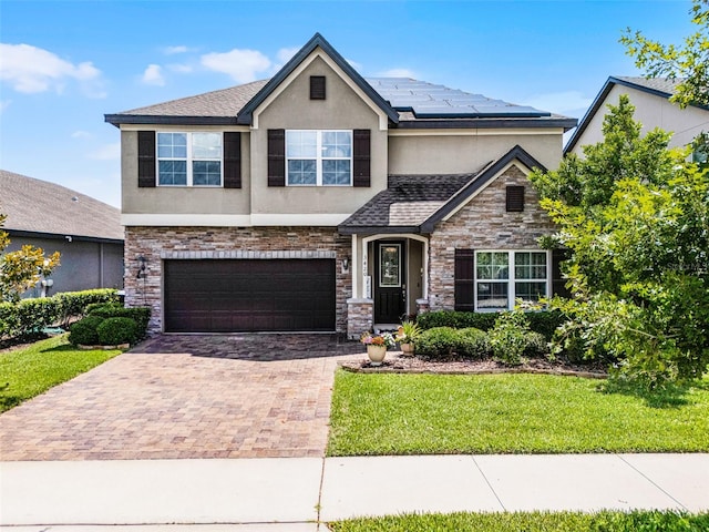 3420 Middlebrook Pl, Harmony, FL 34773 - view of front facade featuring stucco siding, decorative driveway, solar panels, and a front lawn