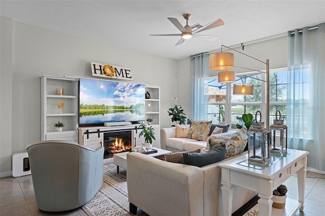 3420 Middlebrook Pl, Harmony, FL 34773 - living area with tile patterned floors, a glass covered fireplace, and a ceiling fan
