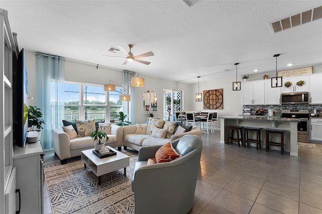 3420 Middlebrook Pl, Harmony, FL 34773 - tiled living area featuring ceiling fan and a textured ceiling