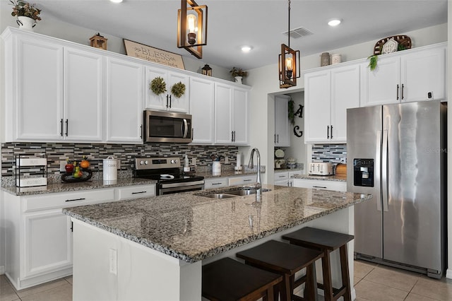 3420 Middlebrook Pl, Harmony, FL 34773 - kitchen featuring appliances with stainless steel finishes, light tile patterned floors, white cabinets, backsplash, and recessed lighting