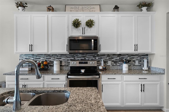 3420 Middlebrook Pl, Harmony, FL 34773 - kitchen featuring stainless steel appliances, white cabinetry, backsplash, and light stone countertops