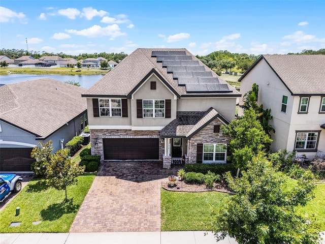 3420 Middlebrook Pl, Harmony, FL 34773 - view of front of property featuring stone siding, decorative driveway, stucco siding, and roof mounted solar panels