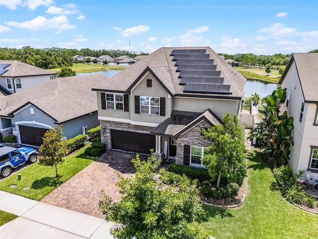3420 Middlebrook Pl, Harmony, FL 34773 - view of front facade with stone siding, stucco siding, decorative driveway, and a water view