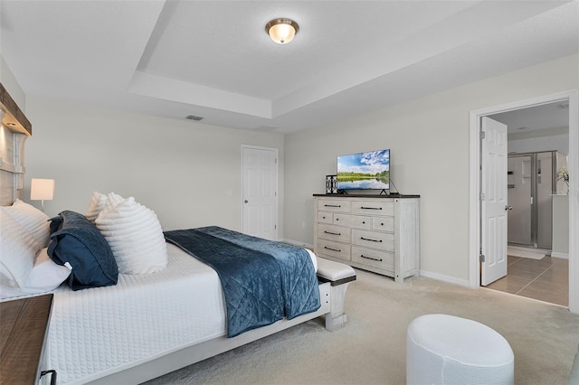 3420 Middlebrook Pl, Harmony, FL 34773 - bedroom with light carpet, a raised ceiling, and ensuite bath