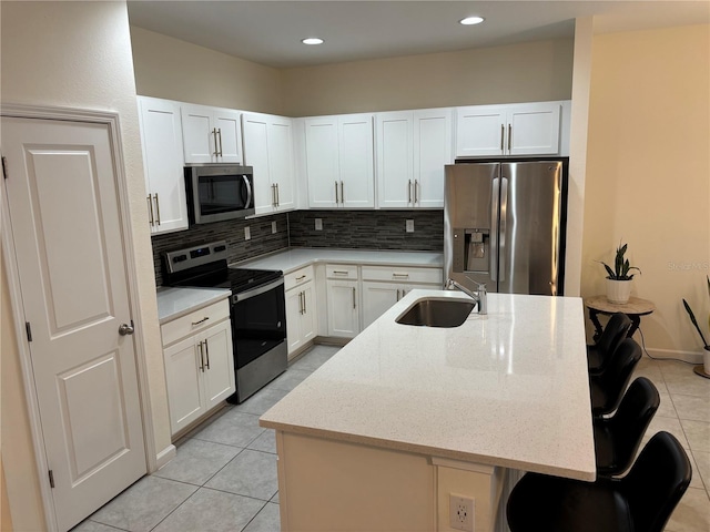 3476 Yarian Dr, Haines City, FL 33844 - kitchen with stainless steel appliances, a sink, decorative backsplash, light tile patterned flooring, and white cabinets