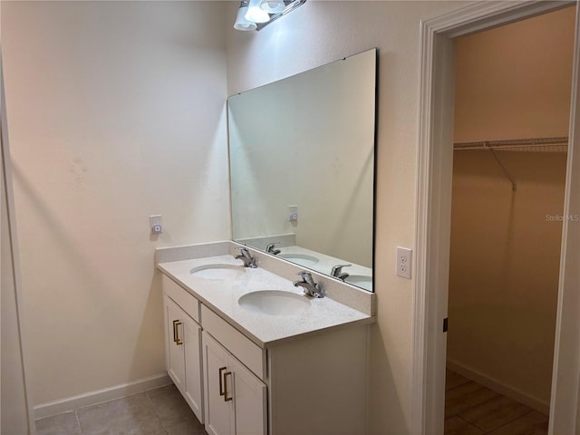 3476 Yarian Dr, Haines City, FL 33844 - bathroom featuring double vanity, baseboards, a spacious closet, and tile patterned flooring