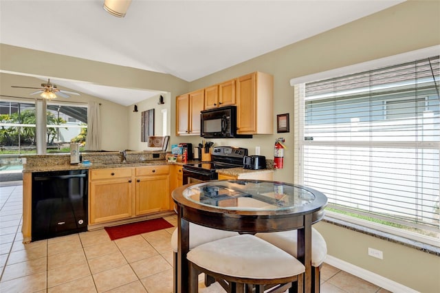737 Oxford Dr, Davenport, FL 33897 - kitchen with black appliances, light brown cabinetry, a peninsula, lofted ceiling, and light tile patterned floors